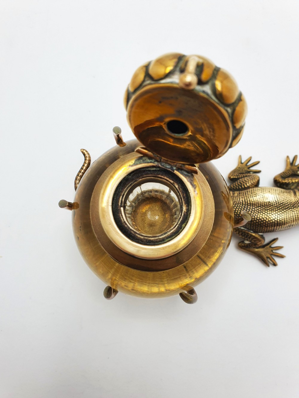 An antique Victorian brass inkstand featuring a cast lizard wrapped around a clear spherical glass inkwell with a crown-shaped hinged lid. View IV