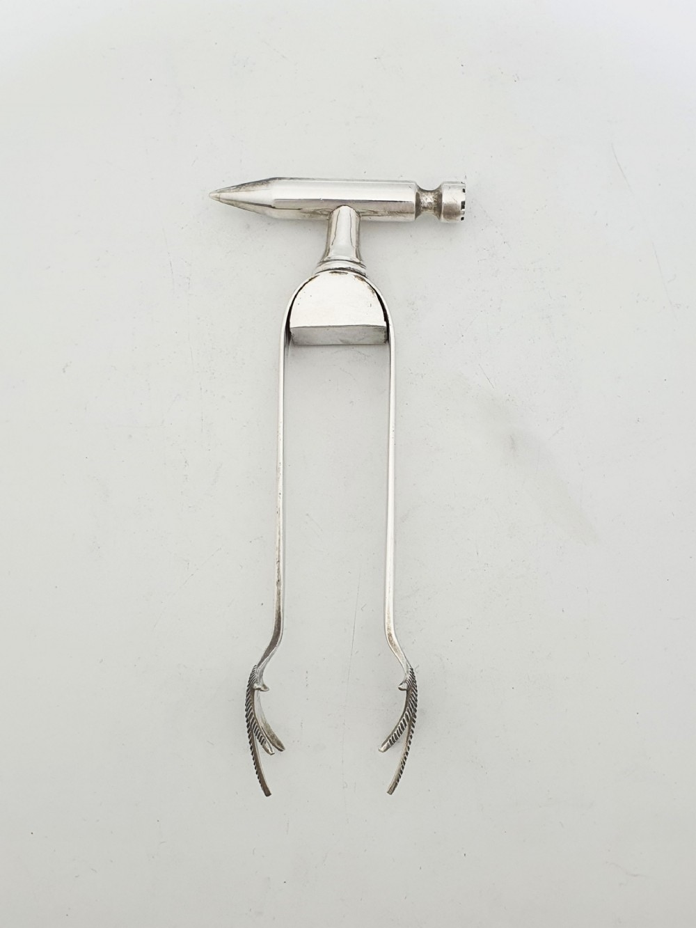 A pair of silver-plated Art Deco ice tongs featuring bird claw grippers and a top-mounted ice pick hammer head.