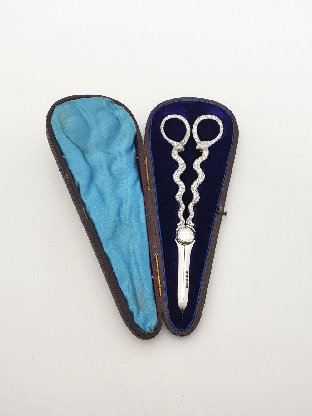 A pair of Victorian silver grape scissors with serpent-shaped handles, presented inside an open velvet-lined protective case. View II