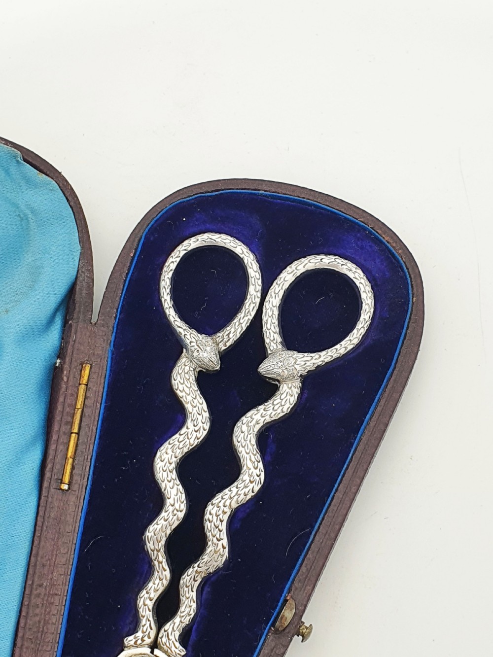 A pair of Victorian silver grape scissors with serpent-shaped handles, presented inside an open velvet-lined protective case. View III