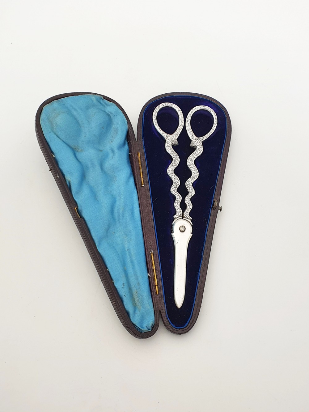 A pair of Victorian silver grape scissors with serpent-shaped handles, presented inside an open velvet-lined protective case. View VI