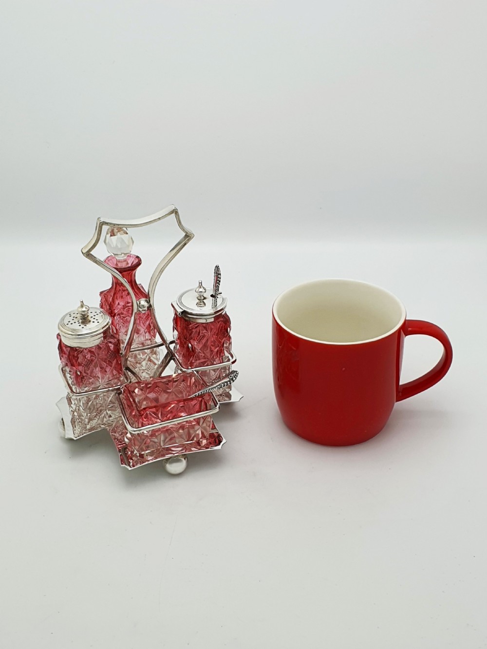 An Edwardian silver-plated stand holding four diamond-cut cranberry flashed glass condiment bottles and jars. View VII
