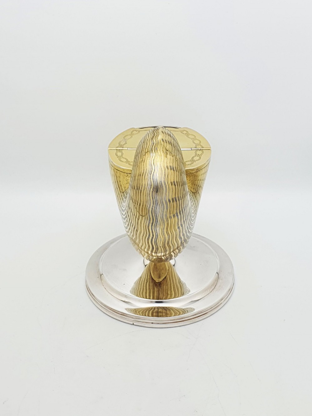 A Victorian silver-plated and gilt metal spoon warmer designed in the form of a nautilus shell on a pedestal base. View V