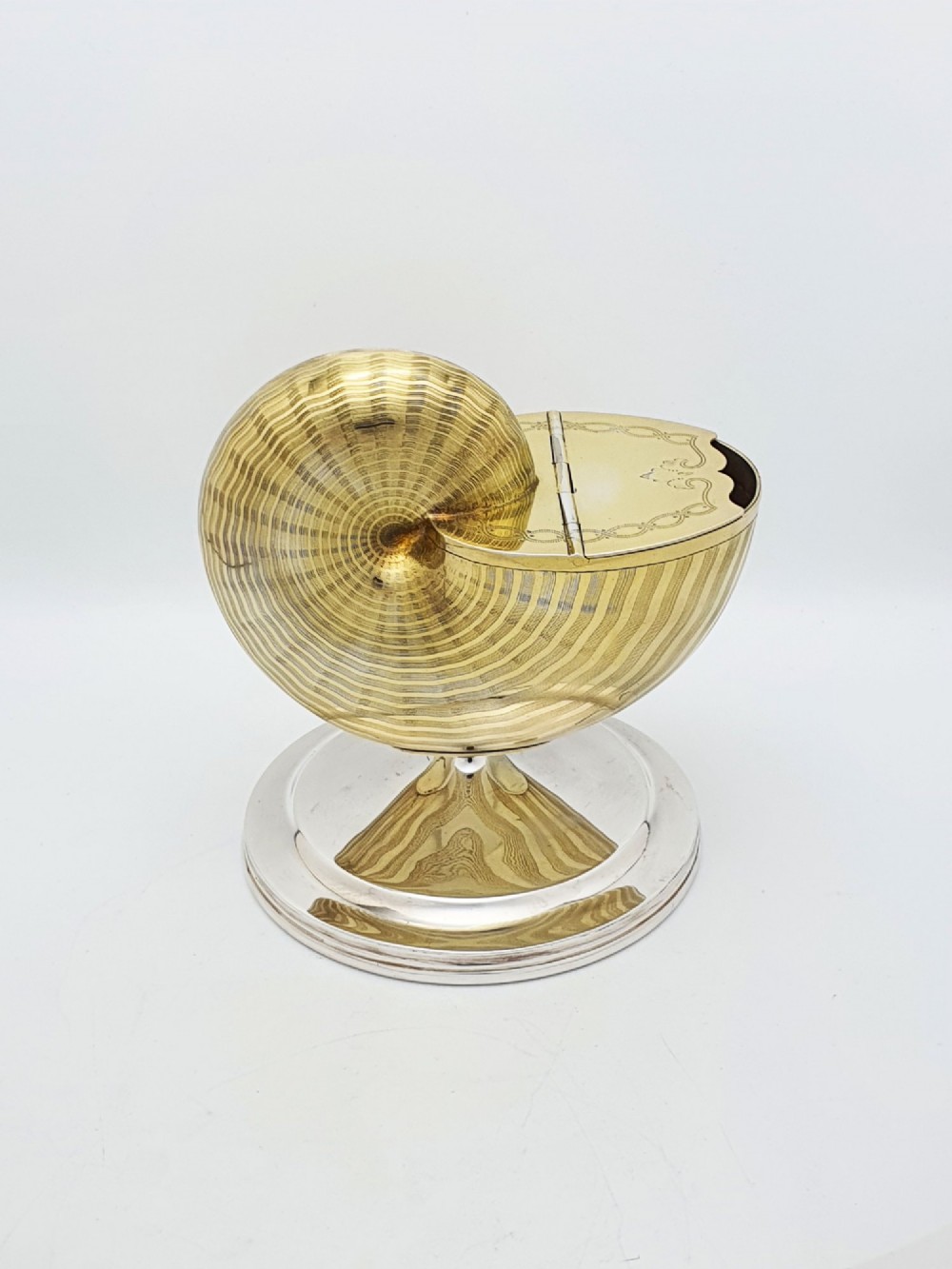 A Victorian silver-plated and gilt metal spoon warmer designed in the form of a nautilus shell on a pedestal base. View VI