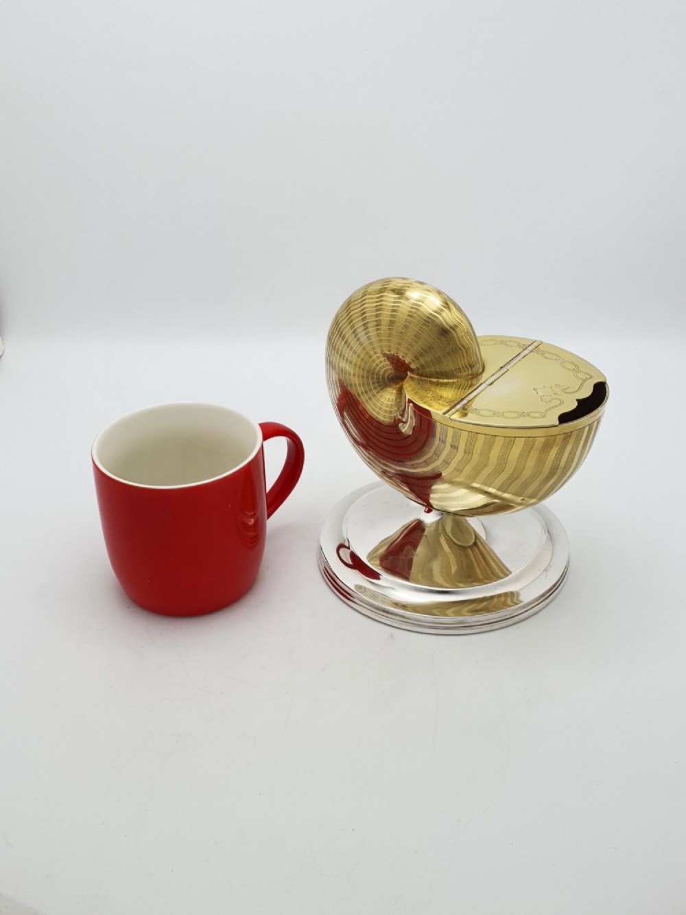 A Victorian silver-plated and gilt metal spoon warmer designed in the form of a nautilus shell on a pedestal base. View X