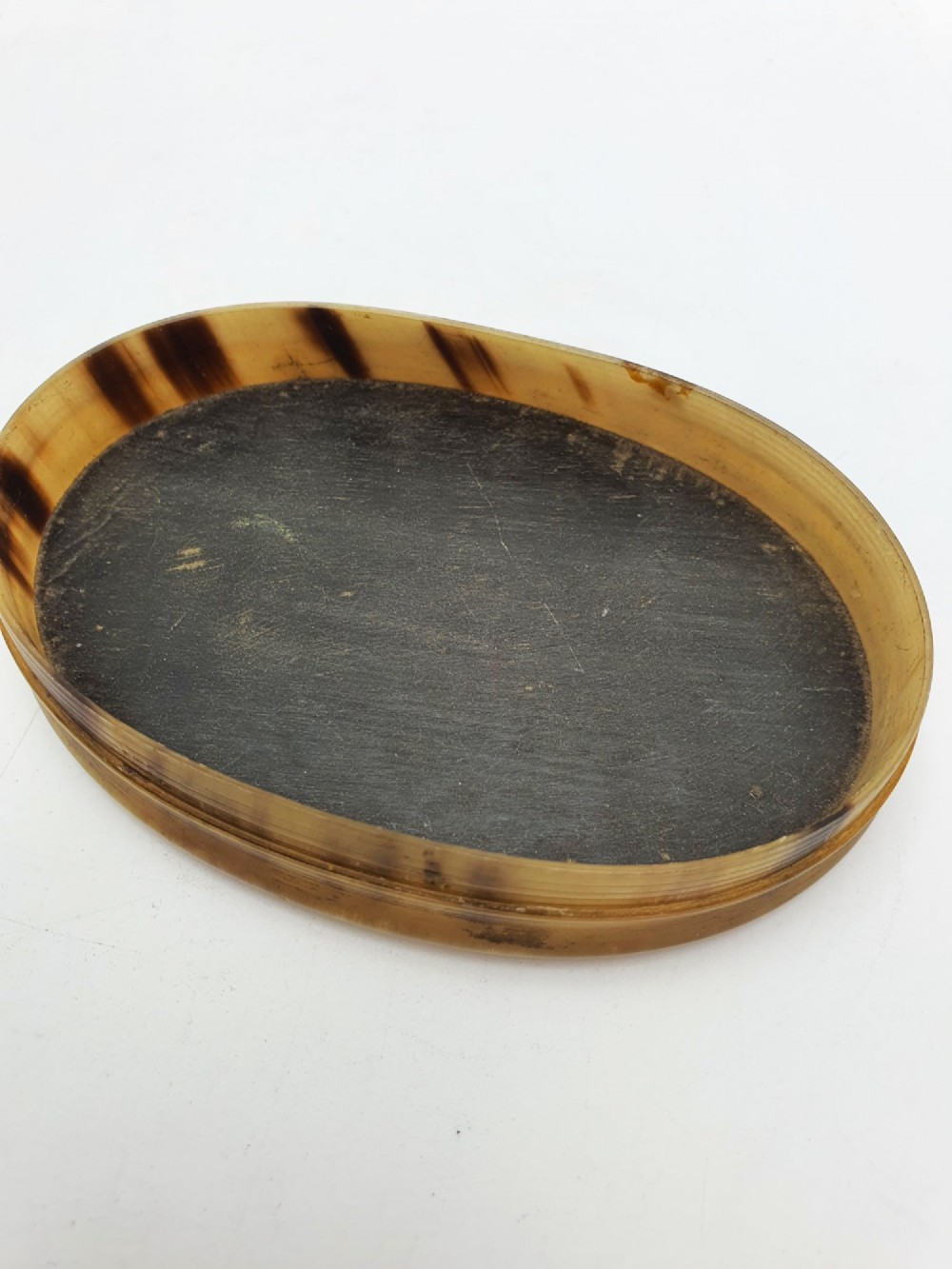 An oval Victorian snuff box made from natural mottled horn featuring a central faceted yellow citrine gem mounted on the lid. View IV