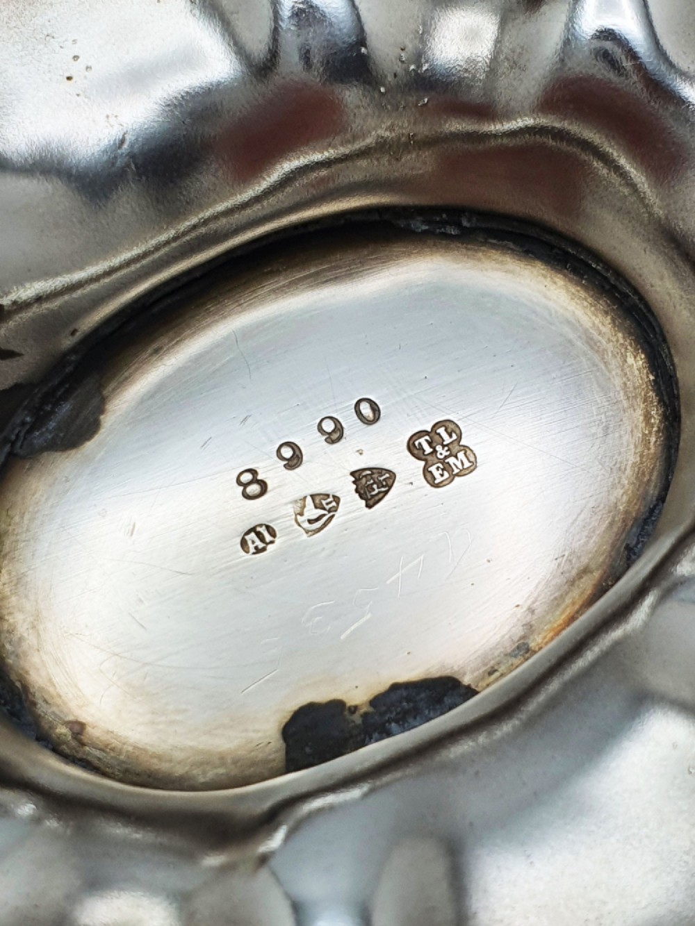 An Edwardian silver-plated oval basket featuring an overhead swing handle, fluted lobes, and a floral repousse rim. View V
