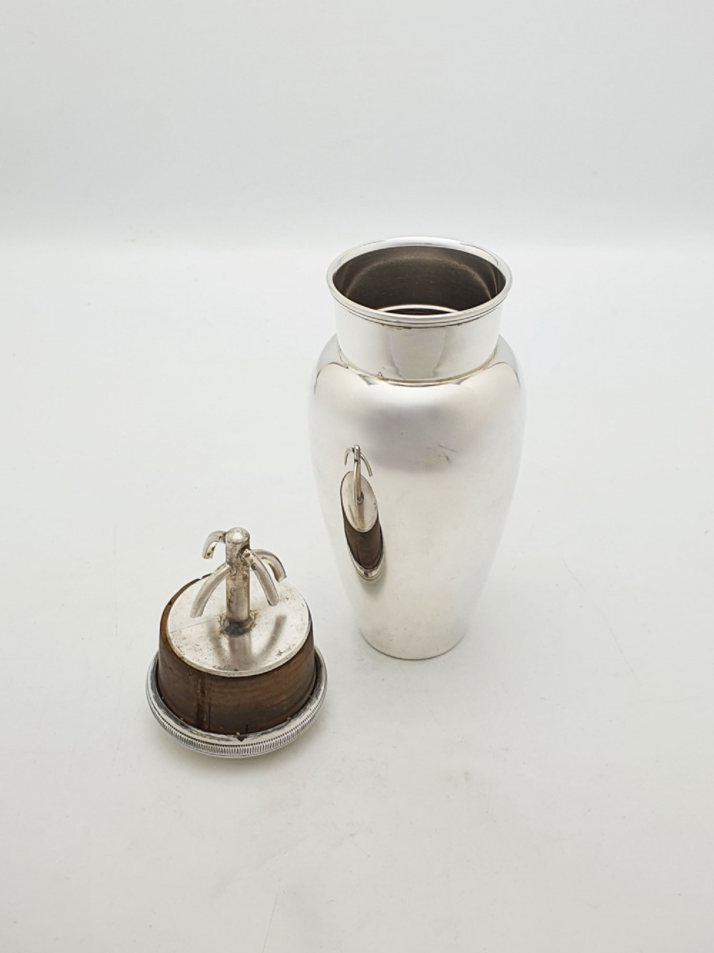 A silver-plated Art Deco bachelor cocktail shaker featuring a baluster body, milled collar, and a domed cap. View II