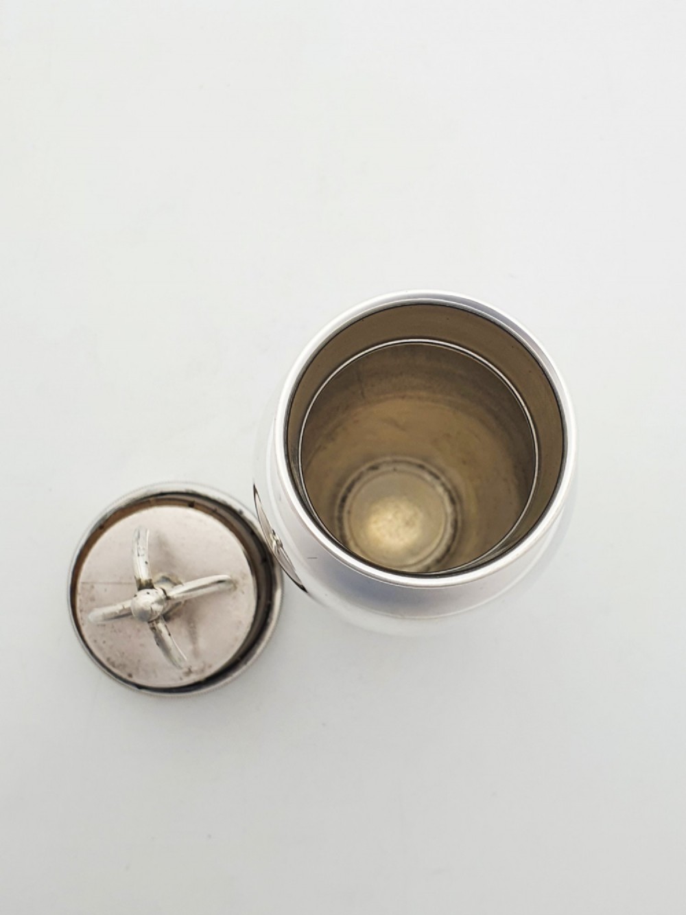 A silver-plated Art Deco bachelor cocktail shaker featuring a baluster body, milled collar, and a domed cap. View III