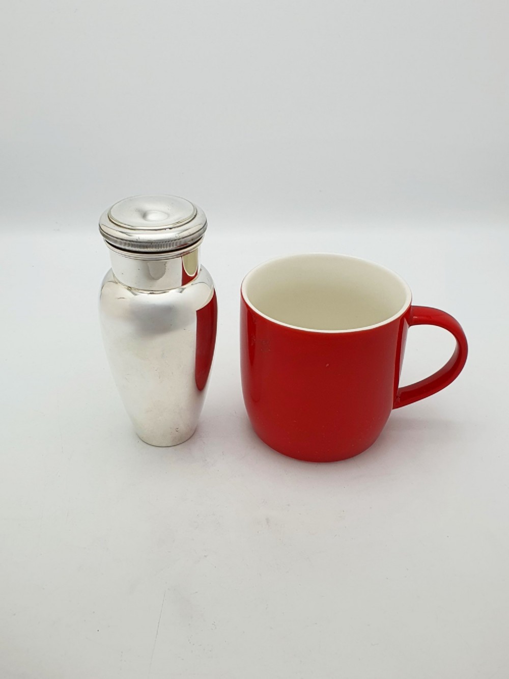 A silver-plated Art Deco bachelor cocktail shaker featuring a baluster body, milled collar, and a domed cap. View V