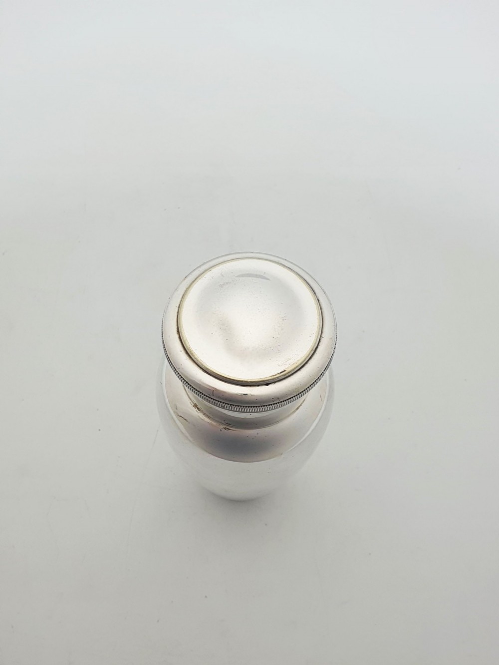 A silver-plated Art Deco bachelor cocktail shaker featuring a baluster body, milled collar, and a domed cap. View VII