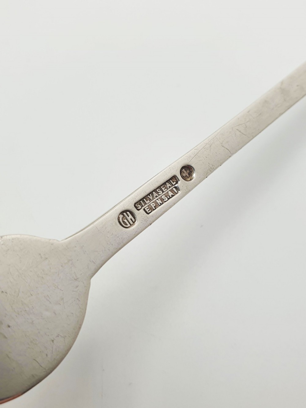 A set of twelve silver-plated lobster picks featuring embossed lobster medallions on the handles and narrow two-pronged tips, arranged neatly in a diagonal row. View V