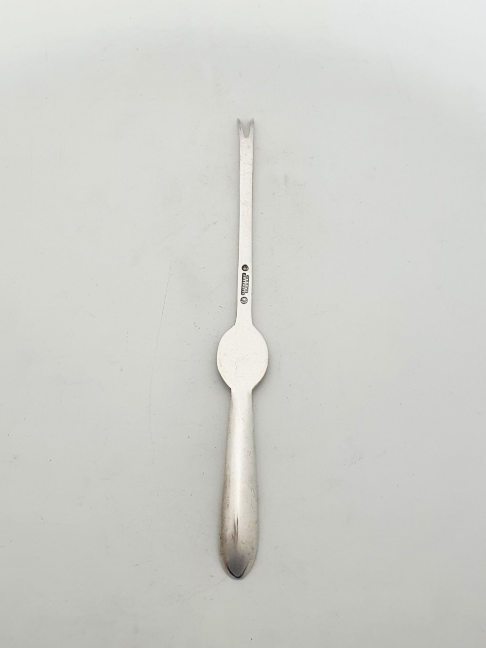 A set of twelve silver-plated lobster picks featuring embossed lobster medallions on the handles and narrow two-pronged tips, arranged neatly in a diagonal row. View VII