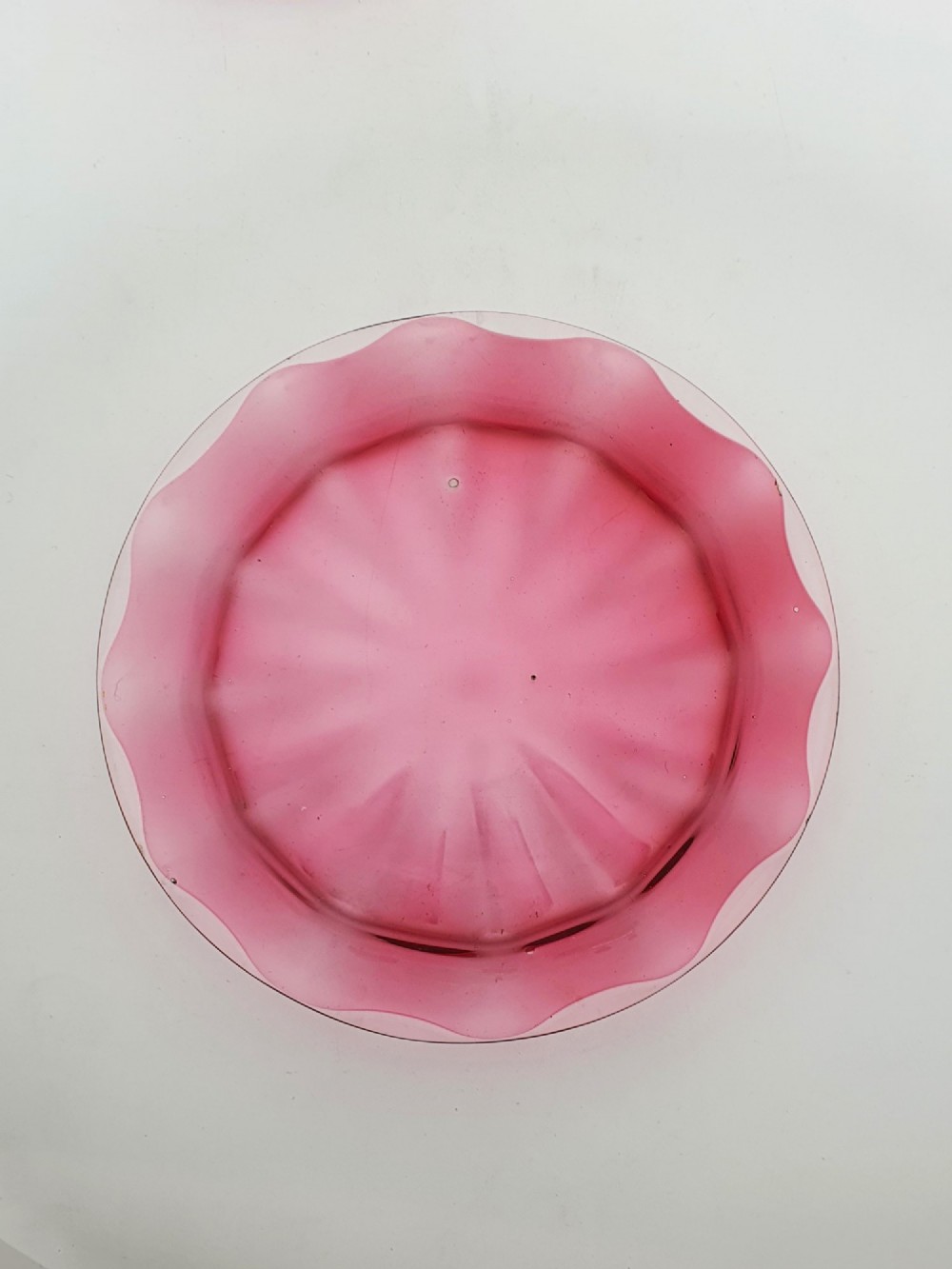 An antique cranberry red glass covered cheese dish featuring gold filigree detailing, floral enamel panels, and a rounded glass knob finial. View VI