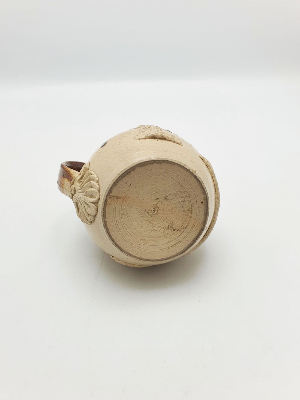 A small salt-glazed brown and beige stoneware jug featuring relief motifs and a hallmarked sterling silver hinged lid and collar. View VIII