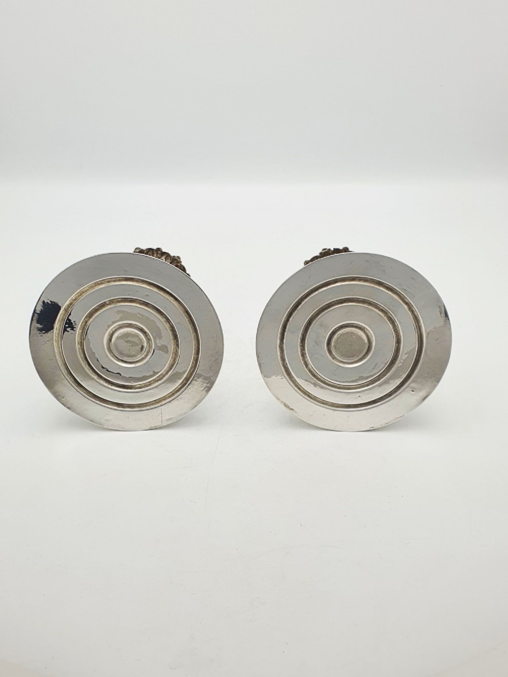 A pair of antique Edwardian low silver-plated candlesticks featuring fluted sockets and gadrooned circular bases. View VII