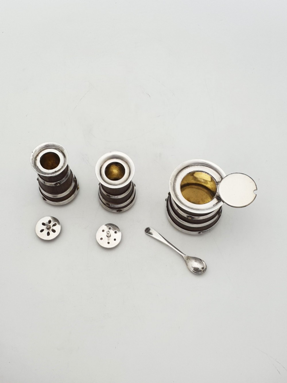 An antique Victorian silver-plated condiment set crafted as a miniature four-wheeled trolley holding three oak barrel-shaped containers. View X