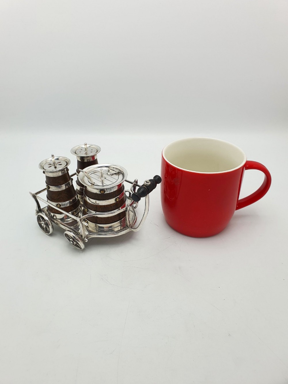 An antique Victorian silver-plated condiment set crafted as a miniature four-wheeled trolley holding three oak barrel-shaped containers. View XI