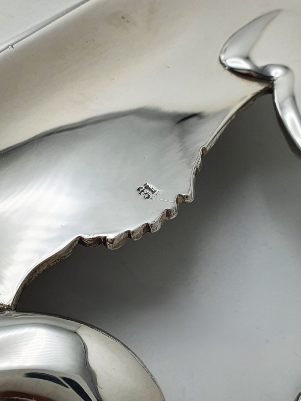 A long rectangular silver plated serving tray featuring an ornate grapevine motif rim, twin cast scroll handles, and an intricately chased floral central surface pattern. View VI