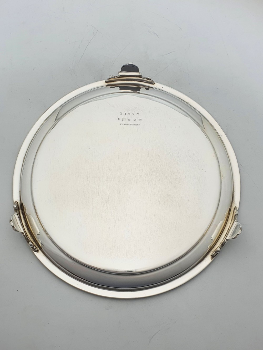 A set of three circular Victorian silver plated salvers arranged in graduated sizes, featuring beaded borders, detailed scroll engraving, and central crests. View VII