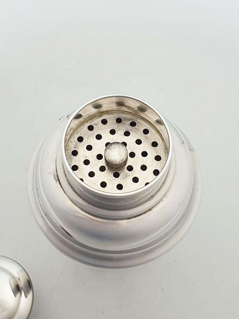 An Art Deco silver-plated cocktail shaker featuring a tapered body, stepped shoulder, and a milled-edge cap. View III
