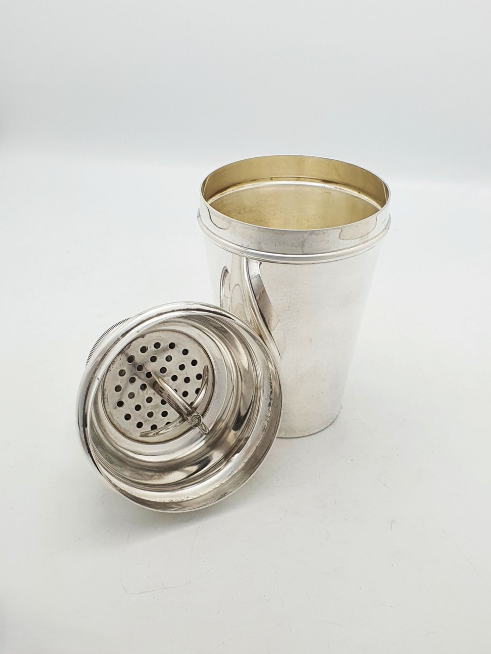 An Art Deco silver-plated cocktail shaker featuring a tapered body, stepped shoulder, and a milled-edge cap. View IV