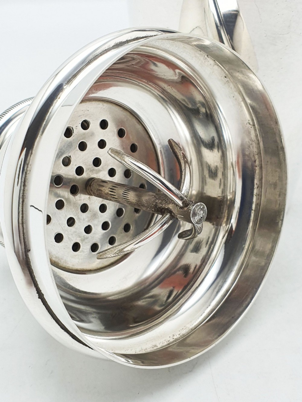 An Art Deco silver-plated cocktail shaker featuring a tapered body, stepped shoulder, and a milled-edge cap. View V
