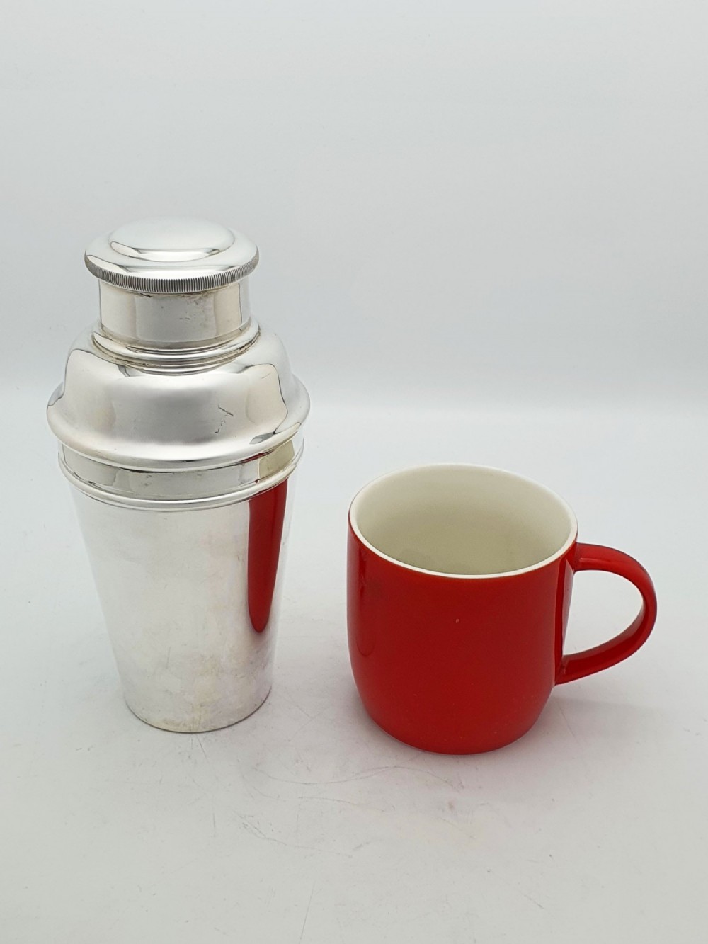 An Art Deco silver-plated cocktail shaker featuring a tapered body, stepped shoulder, and a milled-edge cap. View VI