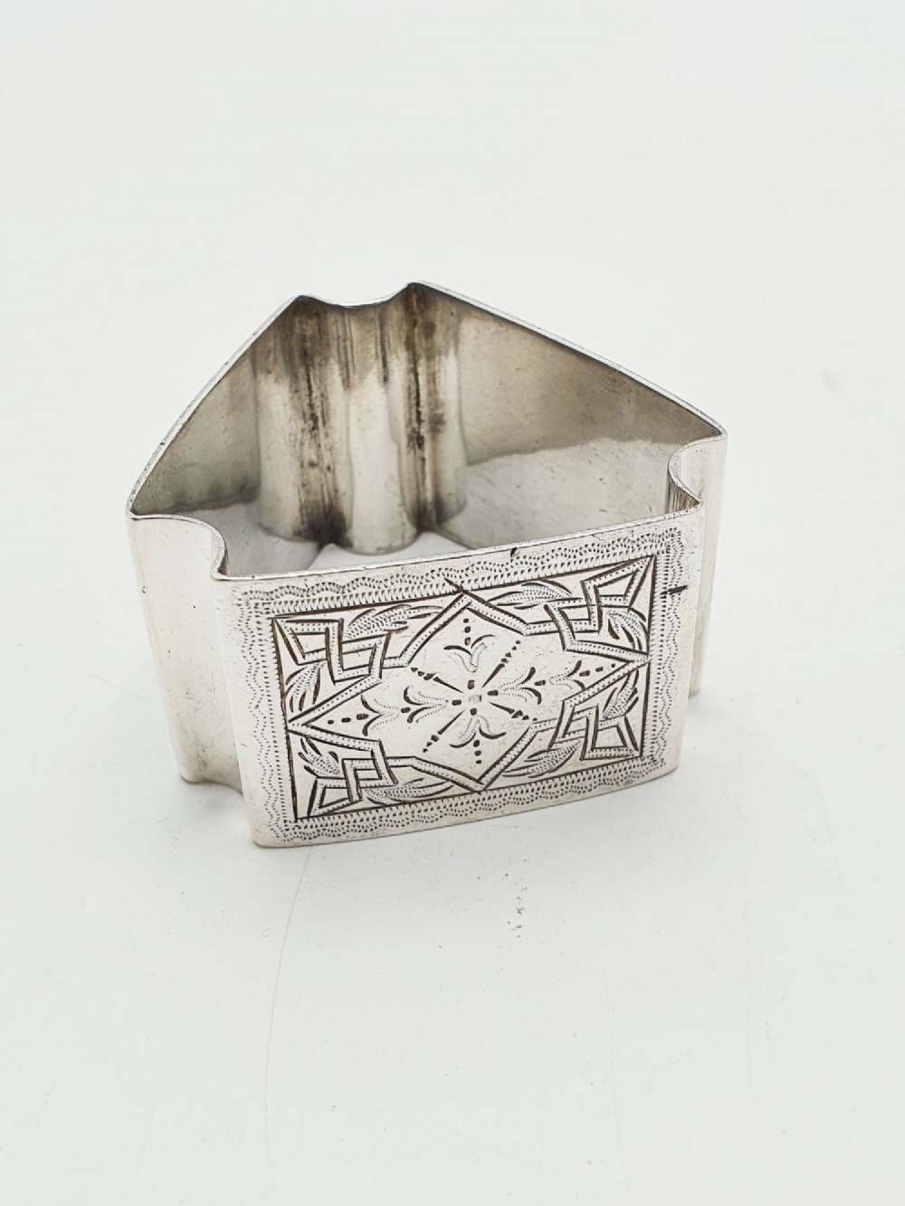 A set of six Edwardian silver-plated napkin rings numbered one through six with engraved geometric borders. View IV