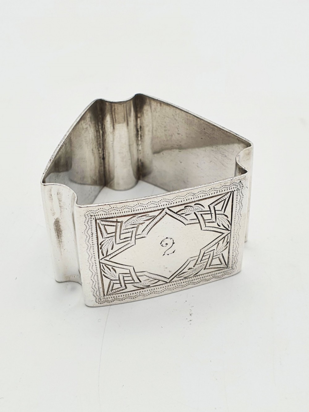 A set of six Edwardian silver-plated napkin rings numbered one through six with engraved geometric borders. View VI