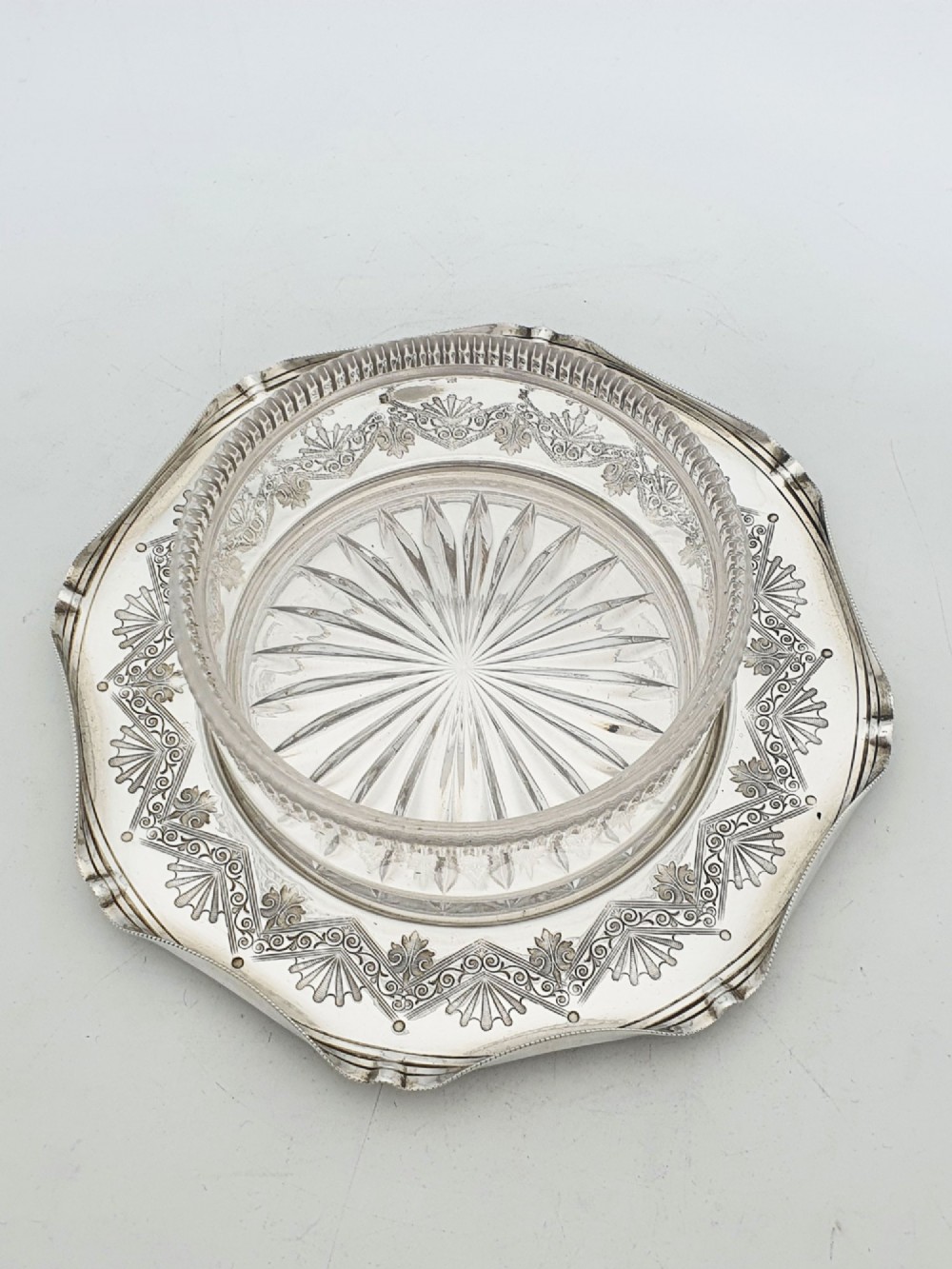 A Victorian silver-plated circular butter dish featuring bright-cut engraving and a lid with a central finial, housing a clear cut-glass liner. View III