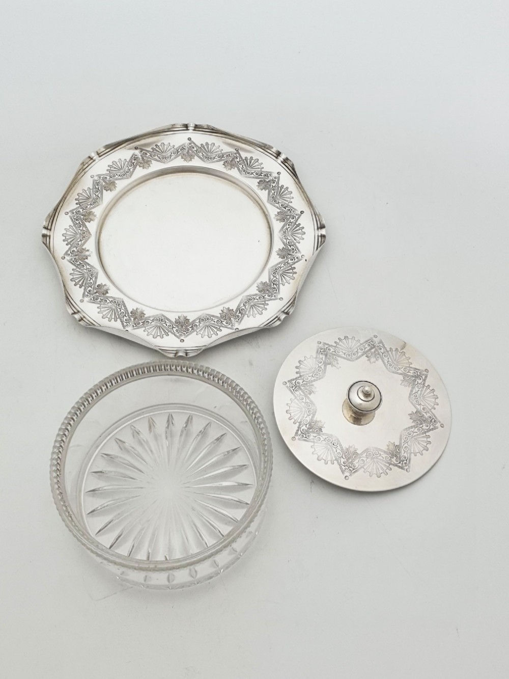 A Victorian silver-plated circular butter dish featuring bright-cut engraving and a lid with a central finial, housing a clear cut-glass liner. View IV
