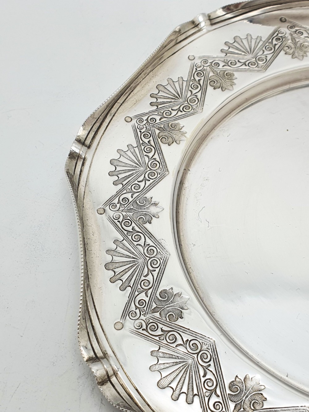 A Victorian silver-plated circular butter dish featuring bright-cut engraving and a lid with a central finial, housing a clear cut-glass liner. View V