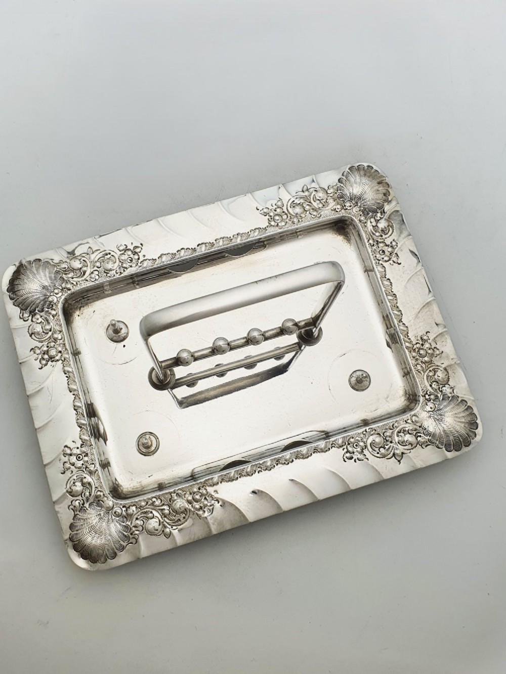 An Edwardian silver-plated egg cruet set with four embossed egg cups, four spoons, and an ornate tray with a central carry handle. View IX