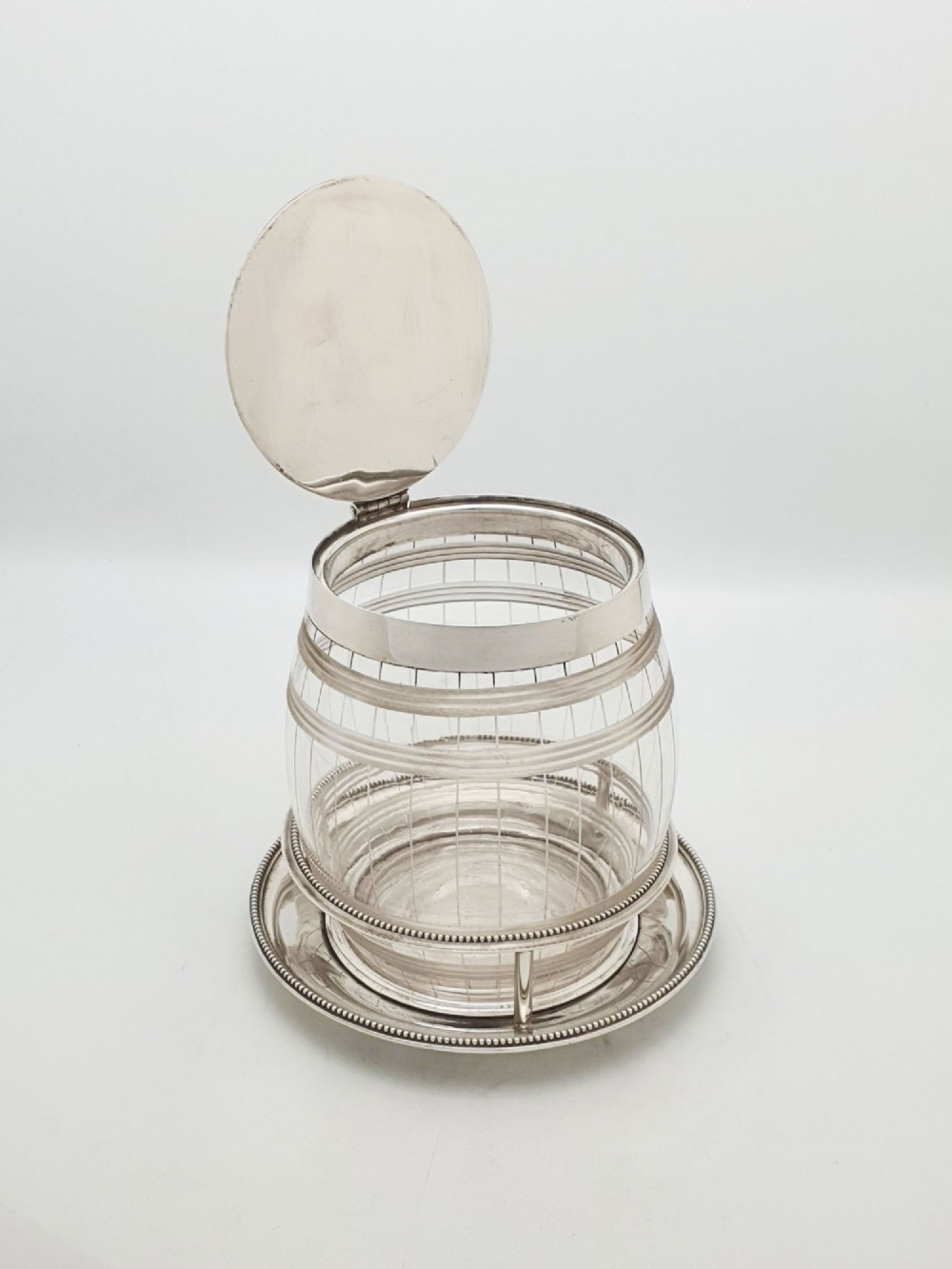 A Victorian cut glass barrel-shaped container with a silver-plated hinged lid and matching stand. View II