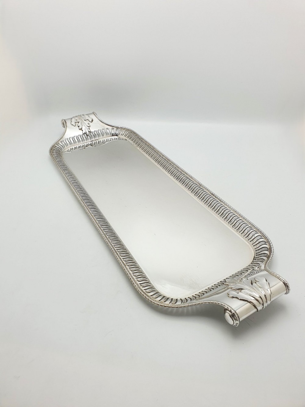 An elongated rectangular silver-plated serving tray featuring a pierced wavy border and leaf-motif end handles. View II
