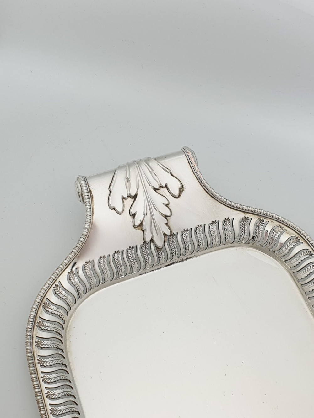 An elongated rectangular silver-plated serving tray featuring a pierced wavy border and leaf-motif end handles. View III