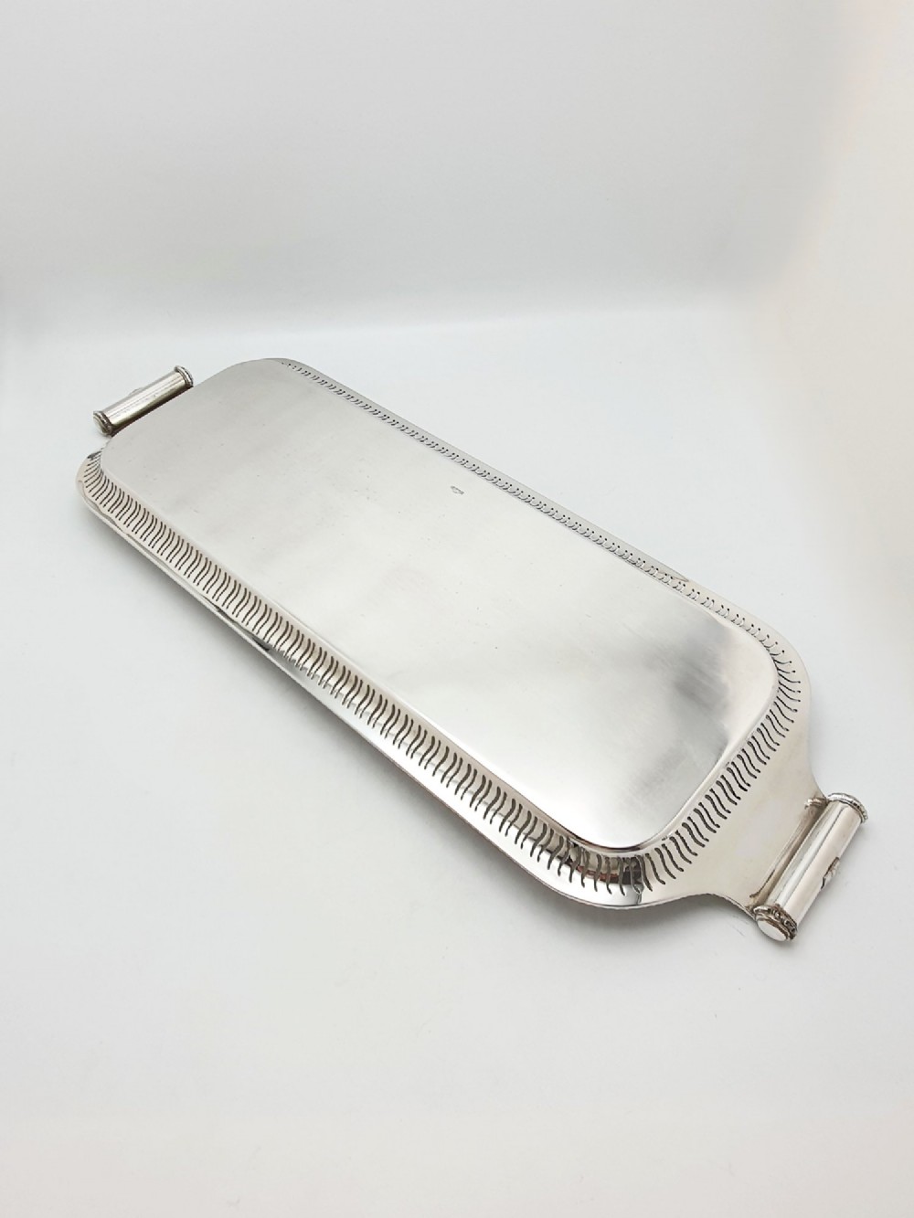 An elongated rectangular silver-plated serving tray featuring a pierced wavy border and leaf-motif end handles. View V