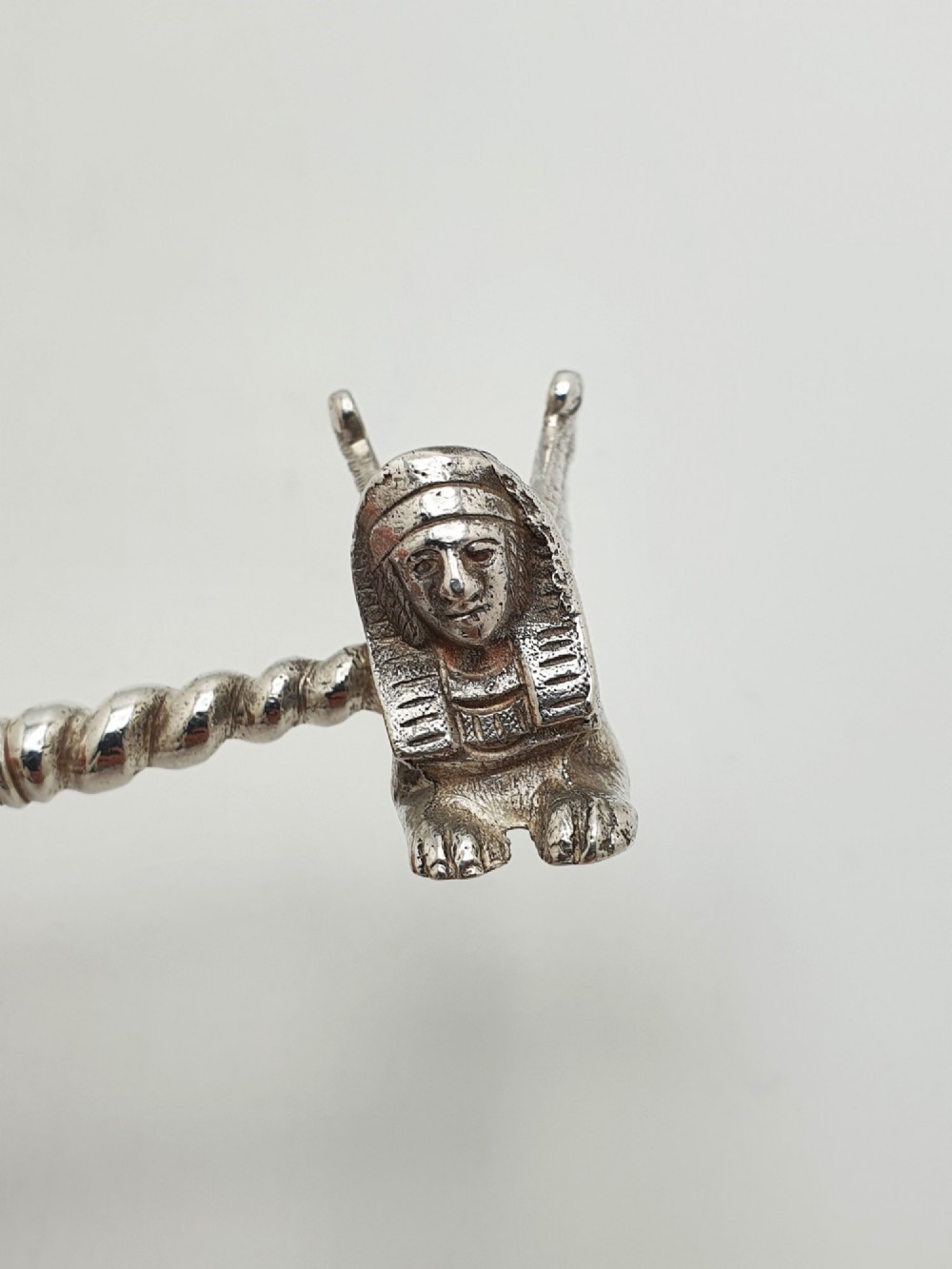 A pair of Victorian silver-plated knife rests featuring winged sphinx end supports connected by a spiral twist bar. View IV