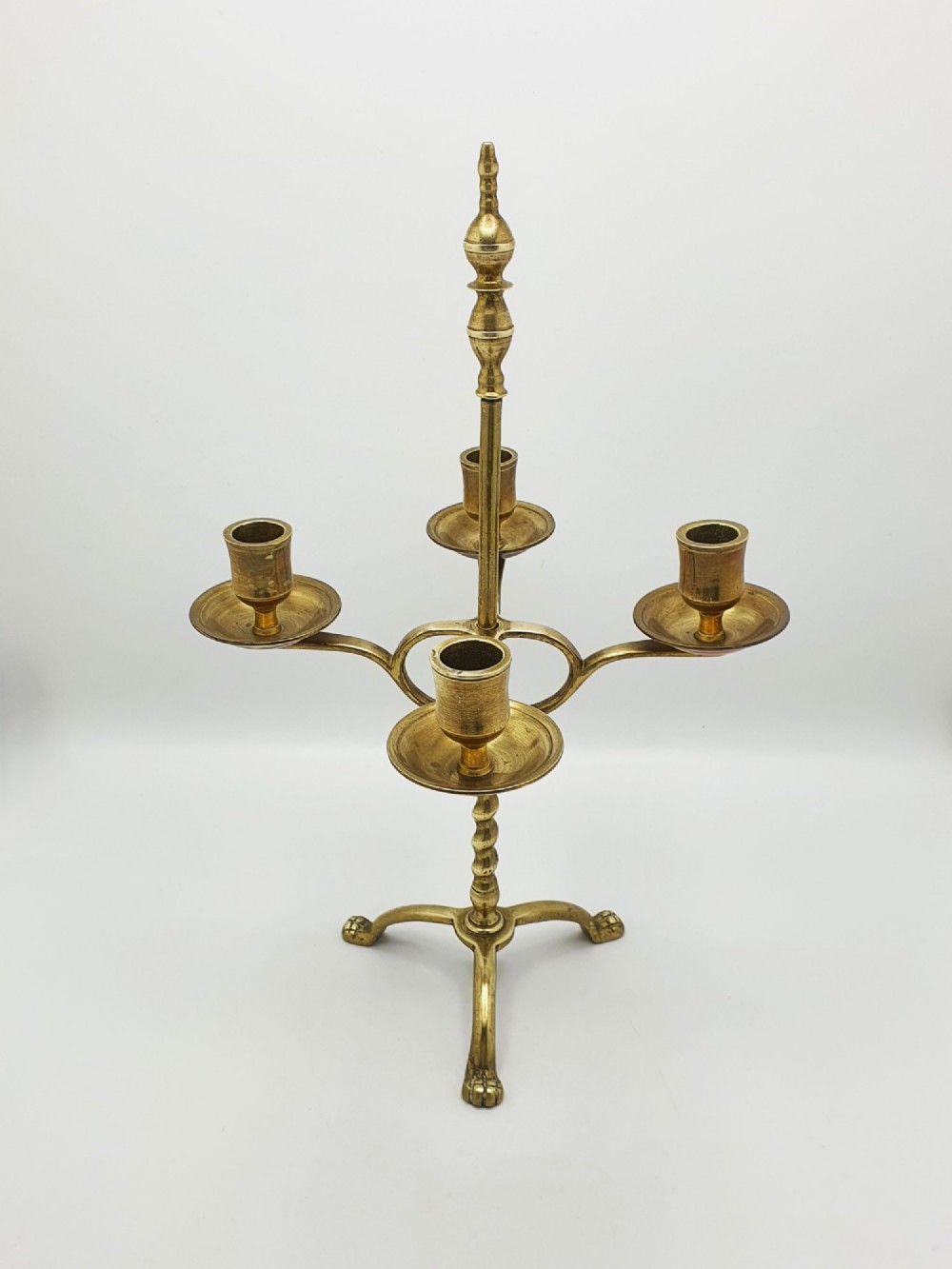 A pair of antique brass four-light adjustable candelabras featuring turned central shafts, tripod feet, and finials. View II
