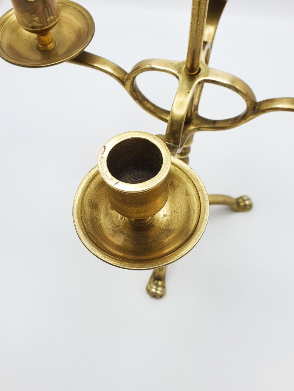 A pair of antique brass four-light adjustable candelabras featuring turned central shafts, tripod feet, and finials. View III
