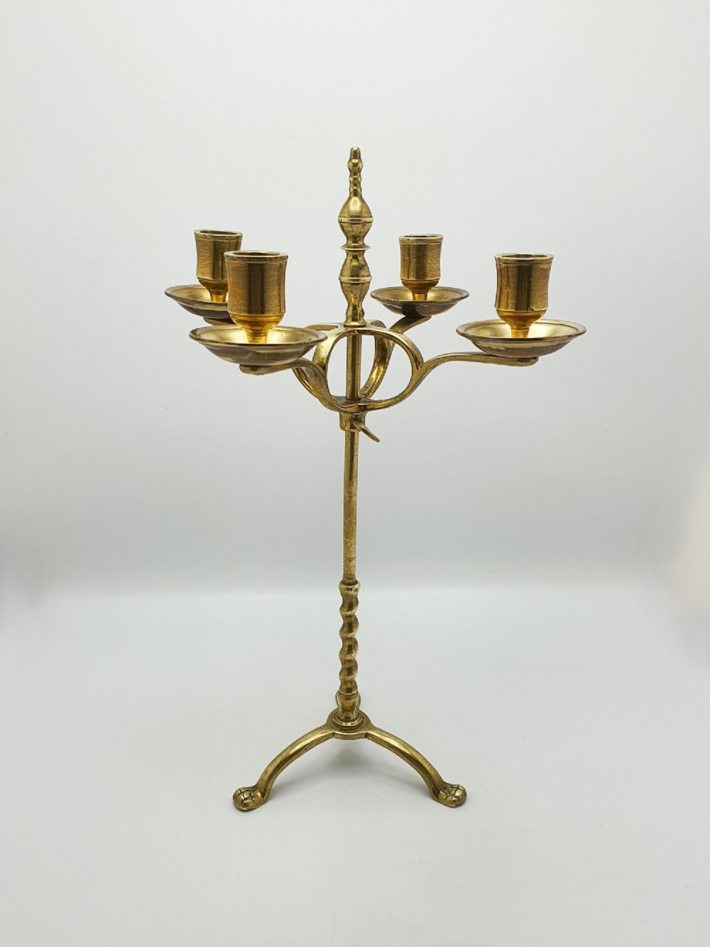 A pair of antique brass four-light adjustable candelabras featuring turned central shafts, tripod feet, and finials. View VII