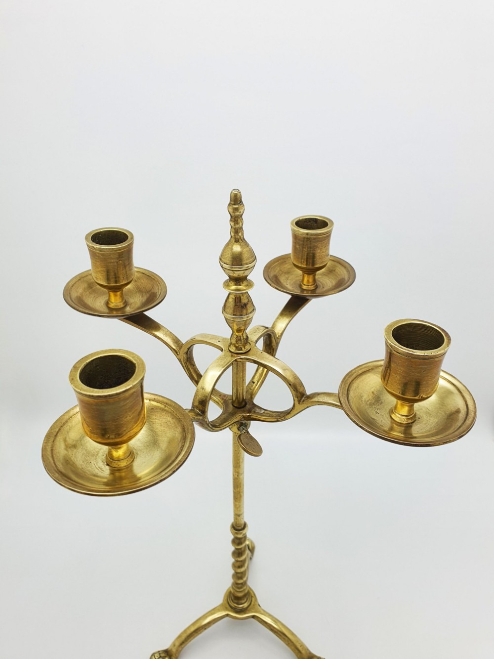 A pair of antique brass four-light adjustable candelabras featuring turned central shafts, tripod feet, and finials. View VIII