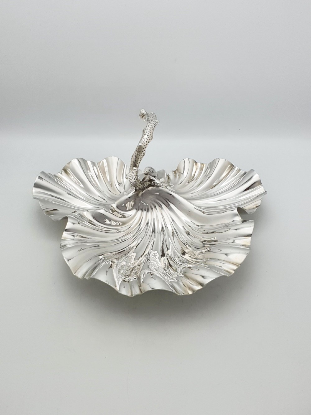 A Victorian silver-plated dish featuring two fluted shell-shaped compartments joined by a central handle modelled as textured coral. View II