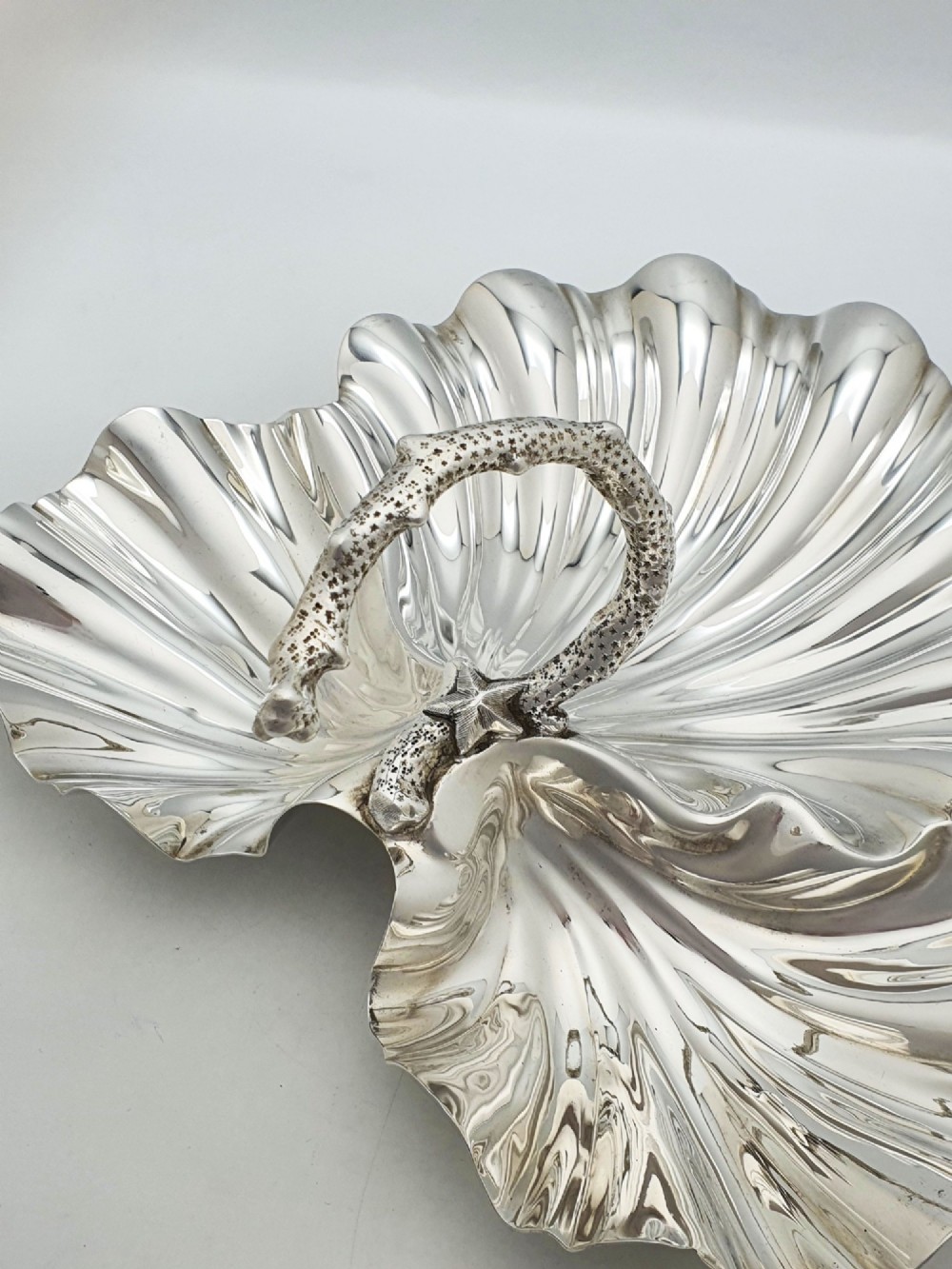 A Victorian silver-plated dish featuring two fluted shell-shaped compartments joined by a central handle modelled as textured coral. View V