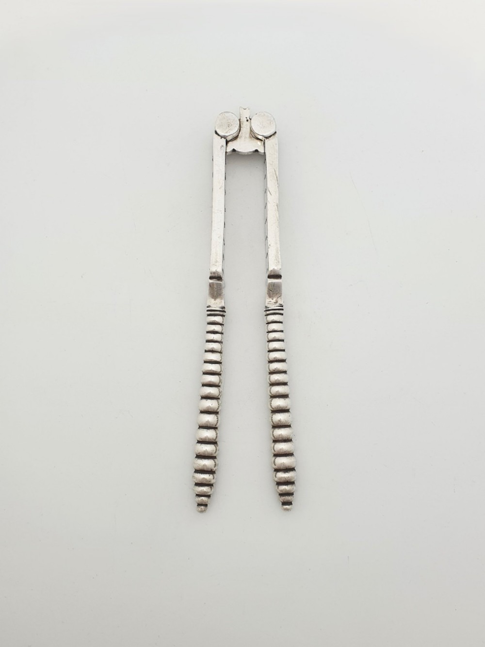 A pair of Victorian silver-plated lobster crackers featuring textured ridged handles and a hinged double-jaw mechanism.
