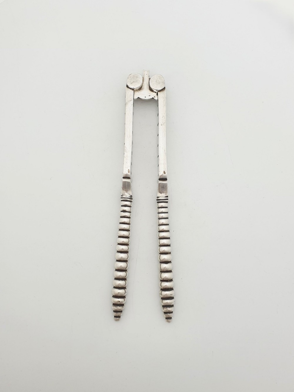 A pair of Victorian silver-plated lobster crackers featuring textured ridged handles and a hinged double-jaw mechanism. View II