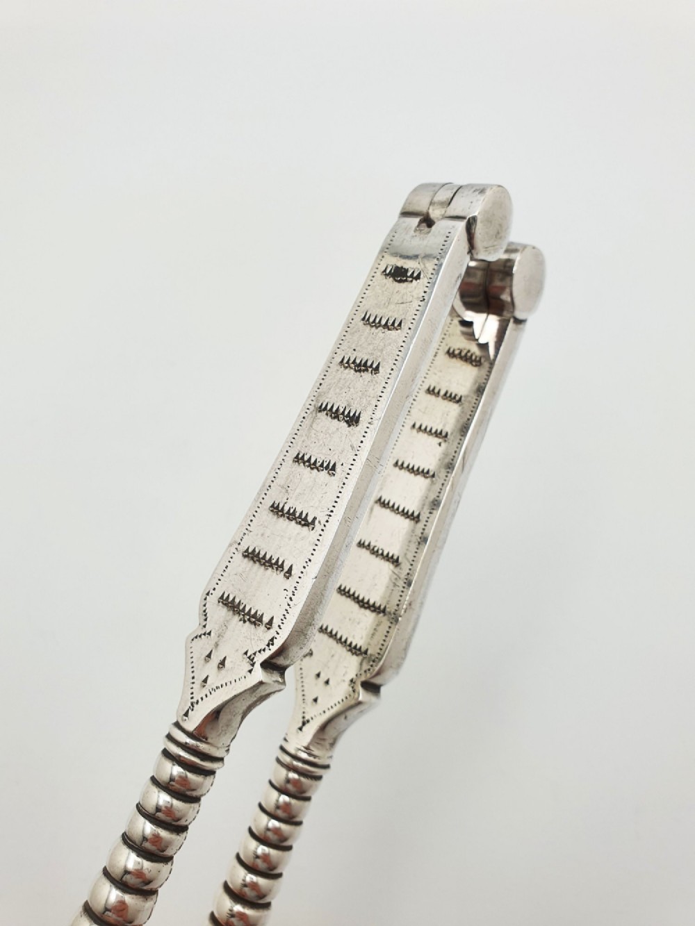 A pair of Victorian silver-plated lobster crackers featuring textured ridged handles and a hinged double-jaw mechanism. View IV