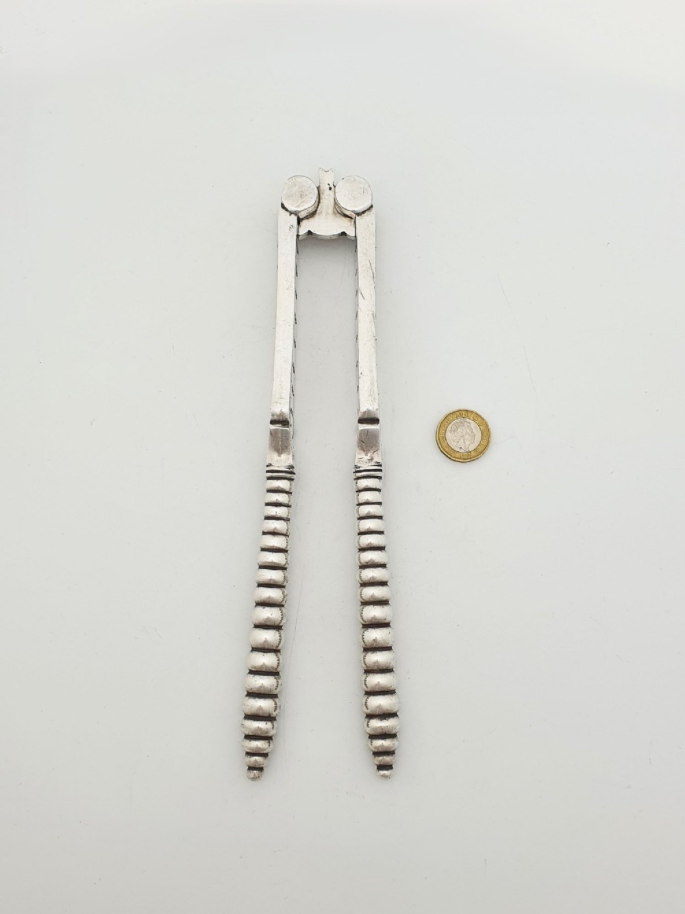 A pair of Victorian silver-plated lobster crackers featuring textured ridged handles and a hinged double-jaw mechanism. View VI