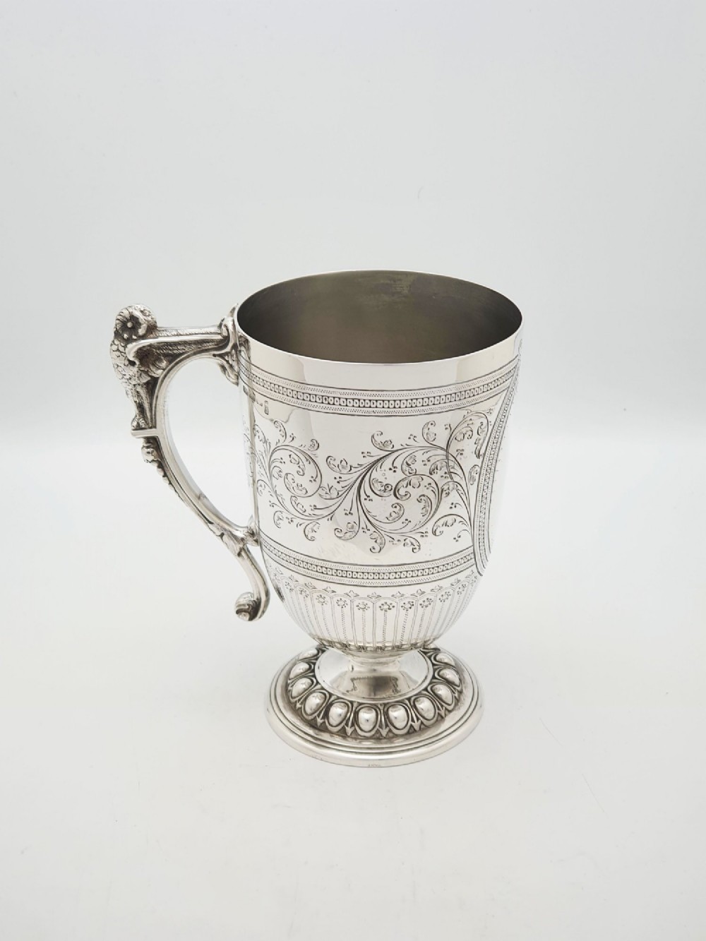 An Edwardian silver-plated tankard with intricate foliate engraving, a fluted pedestal base, and a decorative handle sculpted with an owl motif. View III
